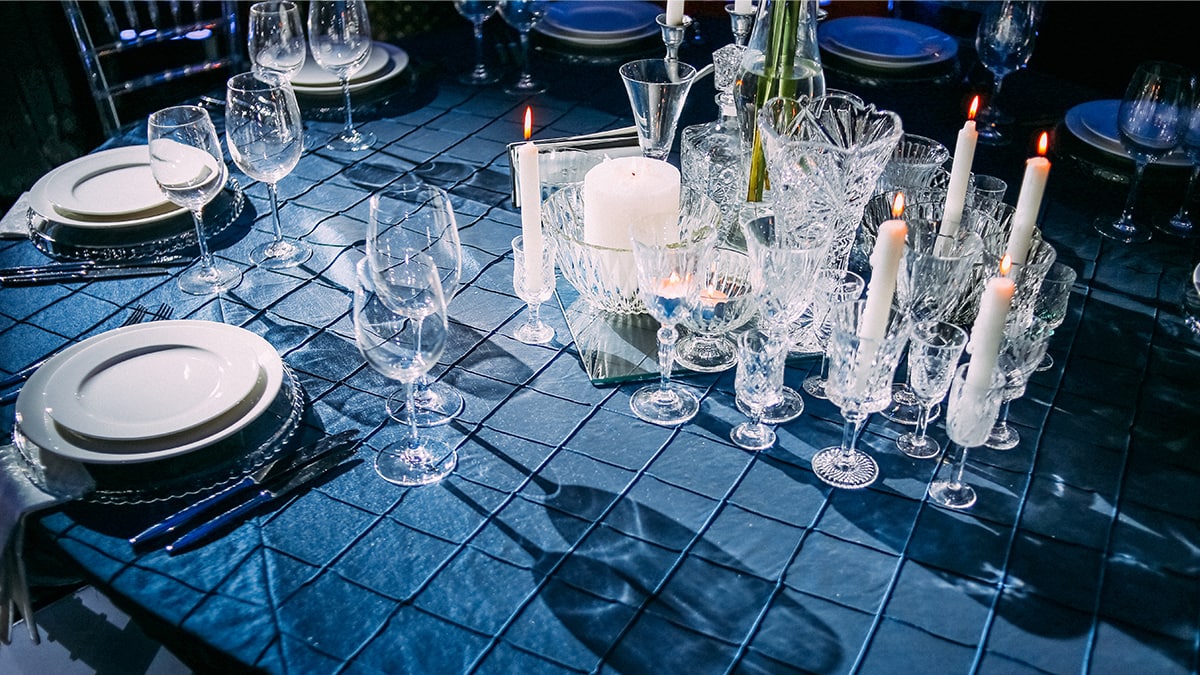 a dining table with elegant glassware like wine glasses, jars, containers etc. 