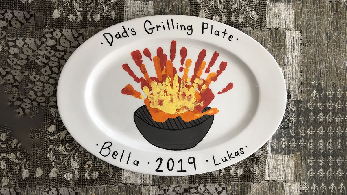 A hand-painted grilling platter with hand imprints on it