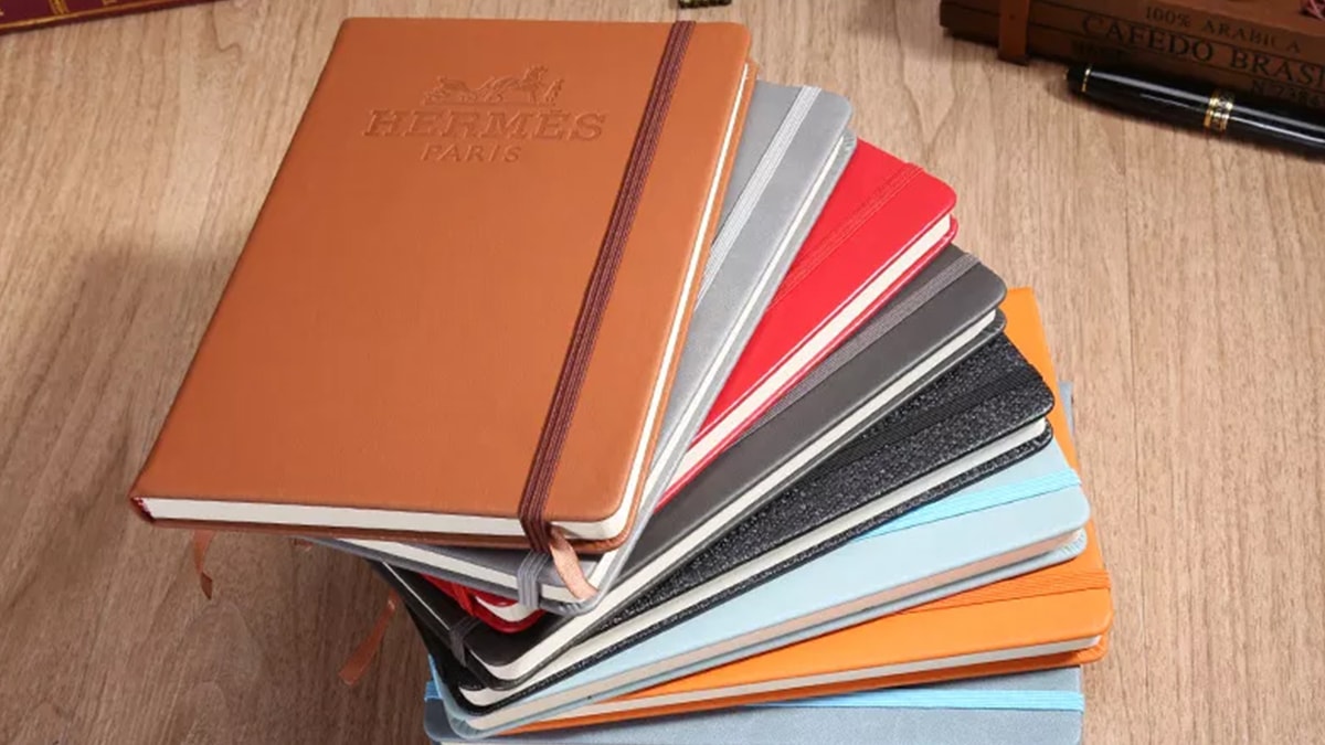 a few hardcover bound letter diaries stacked together.  