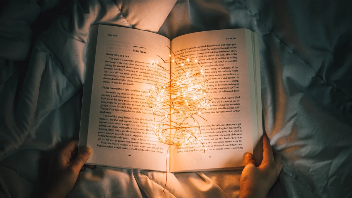Someone holding a book open with fairy lights in between, this is an informational book and is a graduation gift ideas for granddaughter.