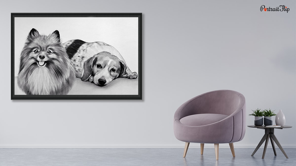 A beautiful portrait that is hung up on a wall with a pretty exterior there is a sofa nd a table with a vase and plant on the table. The portrait is of two dogs and the medium used is charcoal.