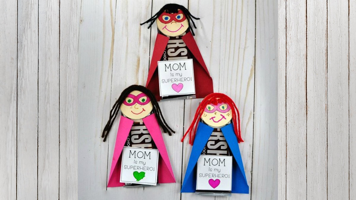 three mother's day superhero card made by kids are kept on a table. 