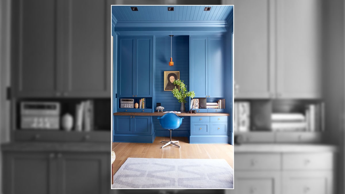 Blue wall bedroom with a home office units and furniture.