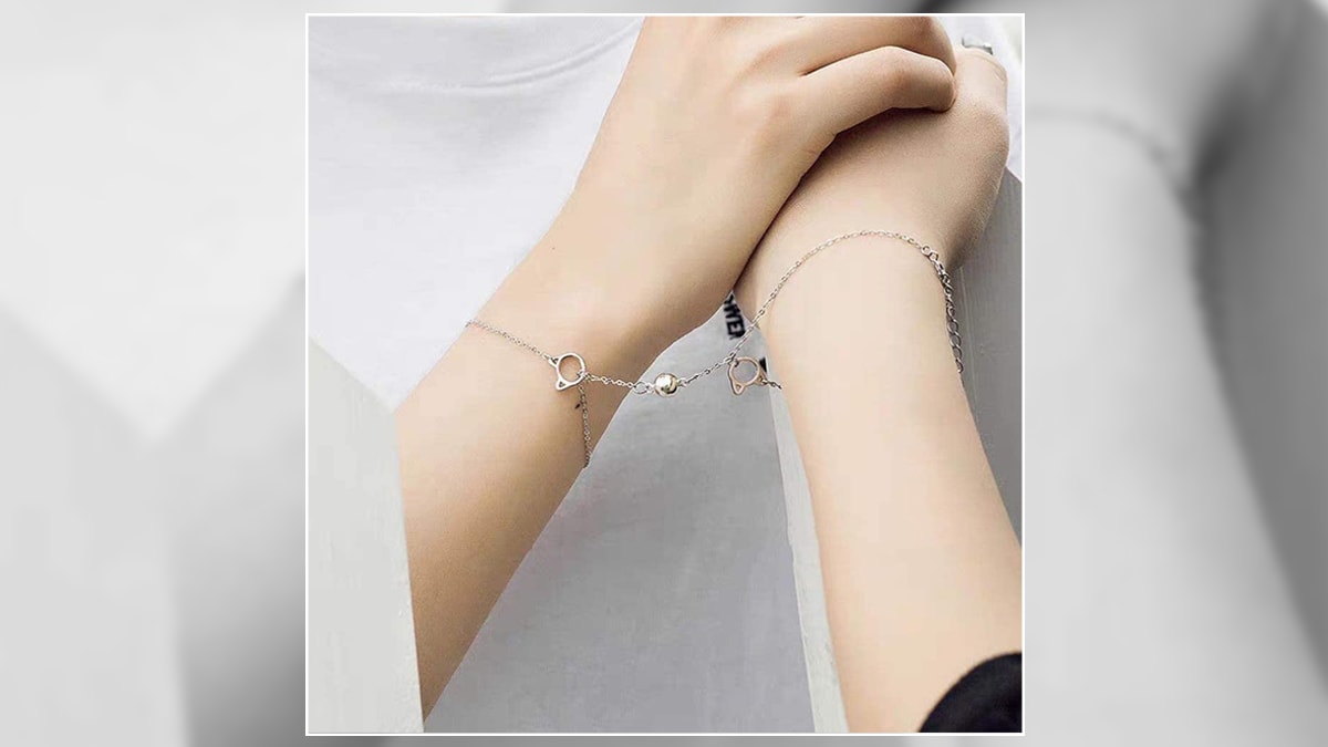 These are connecting bracelets on the hands of two people. They are silver. They are also one of the graduation gifts for best friends.