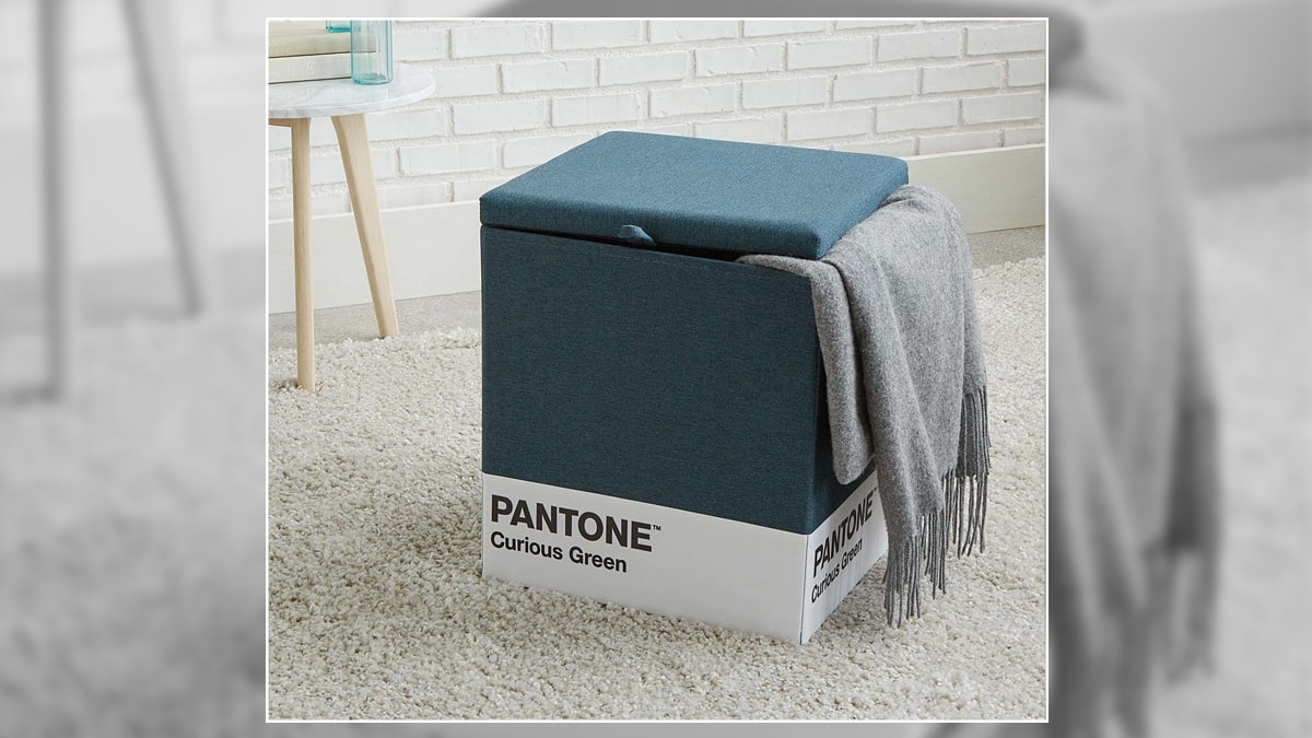 A pantone stool is a storage unit as well as a stool it is blue in color and has the words pantone curious green written on it.