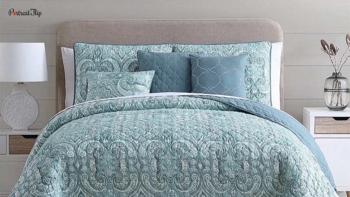 A bed with a variety of different throw pillows. Different textures and styles. This is one of the bedroom decorating ideas and is listed under trends in home decor.