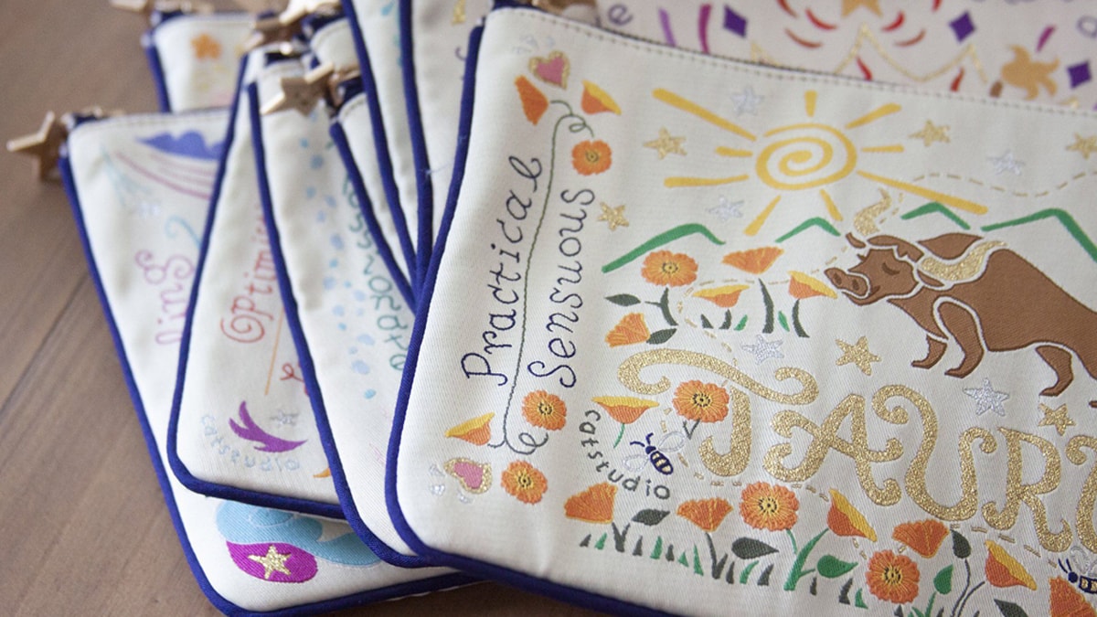 An astrology zip pouch that is customized with beautiful thread work based on different star signs.