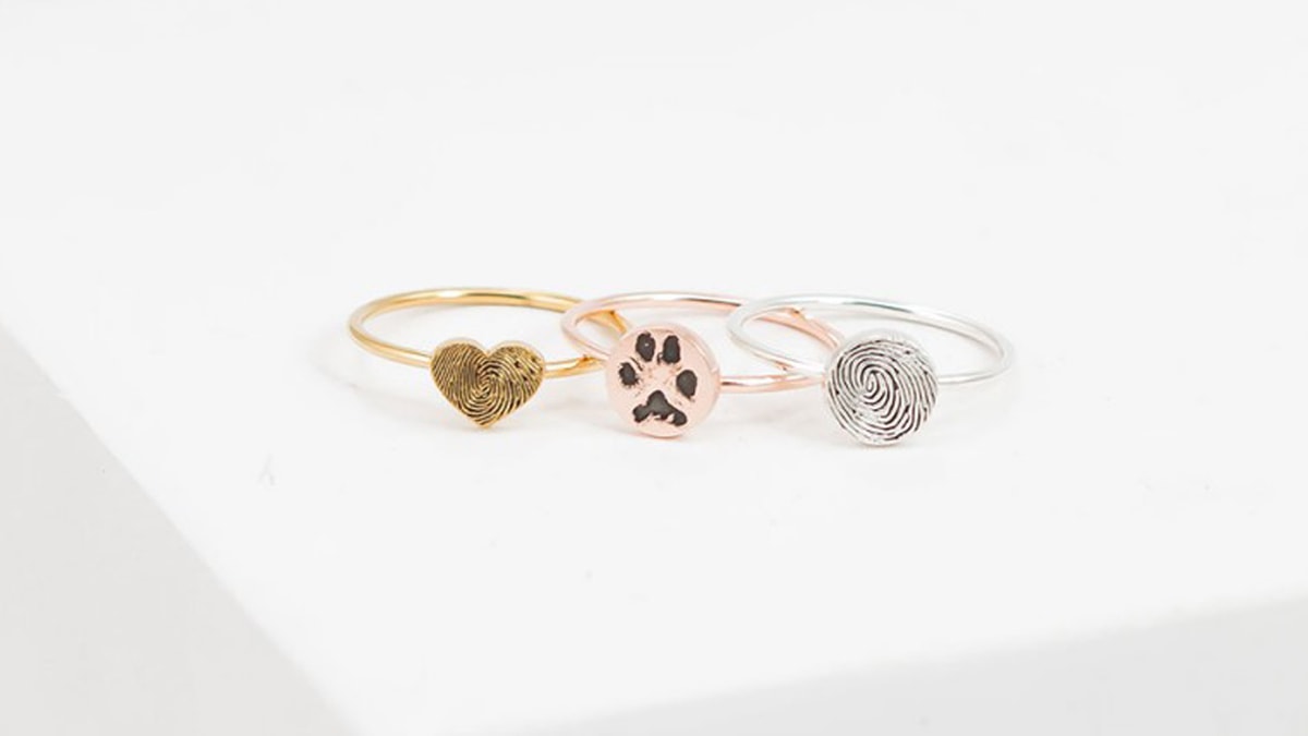 Three different colored paw print rings in golden, rose gold and silver. These rings have custom prints on them that has your beloved pets paw impressions.
