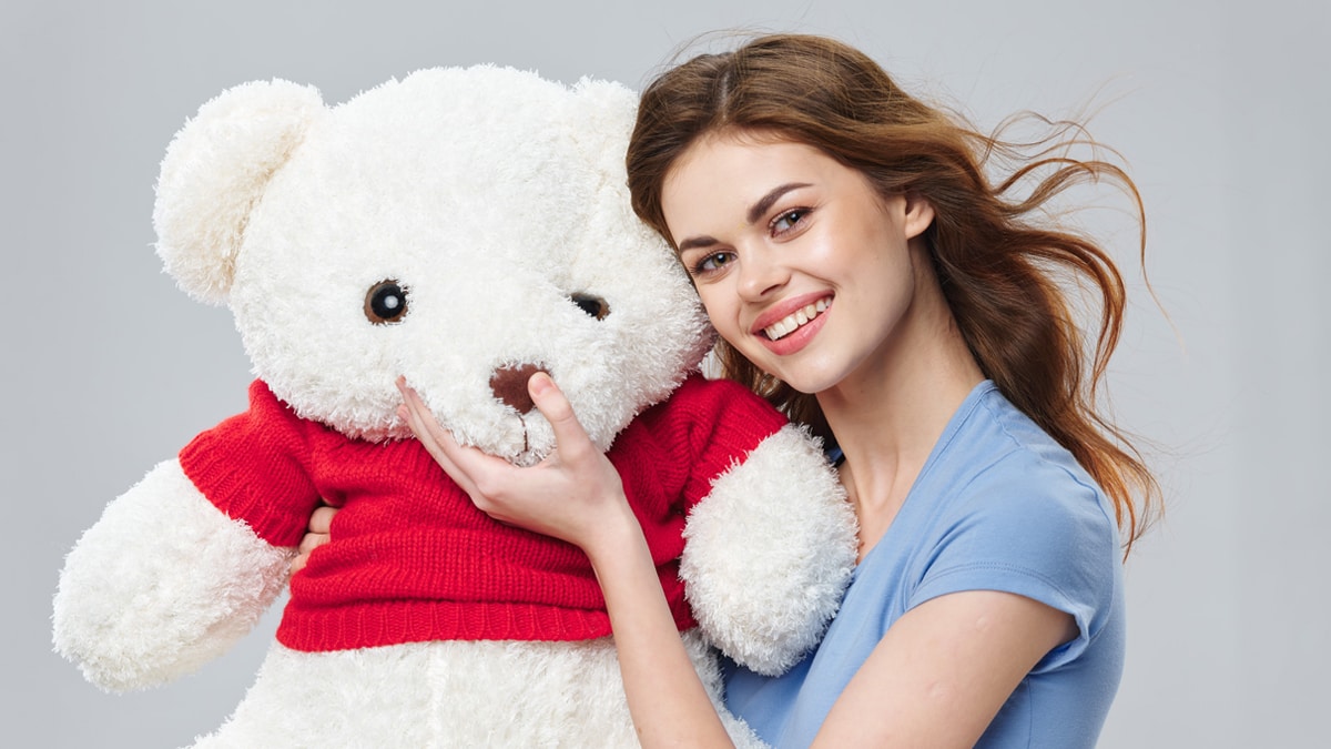 A girl with a white color toy bear.