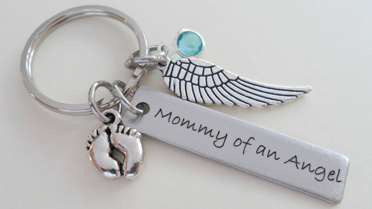 A keychain with the wings of an angel. It reads mommy of an angel.