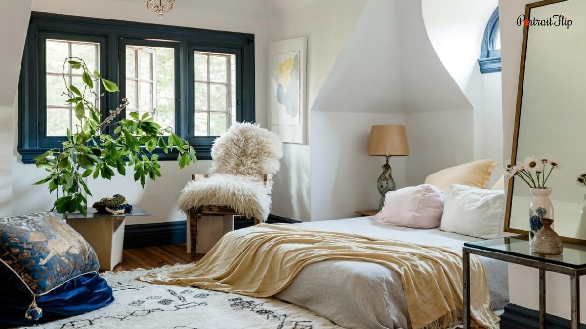A bedroom decorating trend that is sustainable and chic as well. thee is a pretty bed with a lot of mix and matched pillows. A fuzzy coat on the chair and plants.