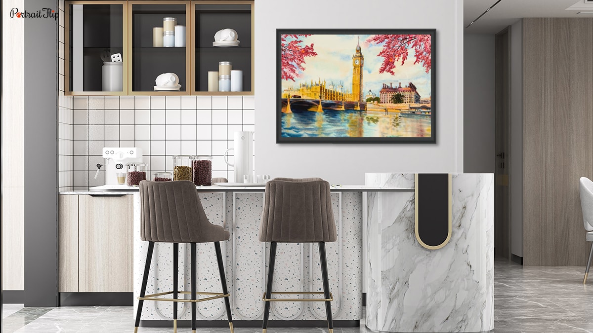 A beautiful interior of a kitchen with a landscape portrait as an art piece. It is brown and white. 