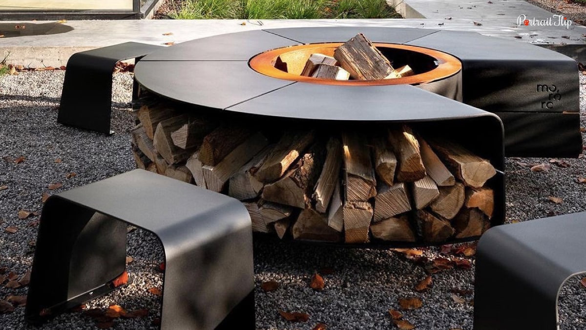 Multi-functional space in the outdoor home decor trend that makes things useful in so many ways. You can store wood and also light up a fire on this bonfire range. There is a fireplace in this image and inbuilt chairs around it. A trend in home decor.