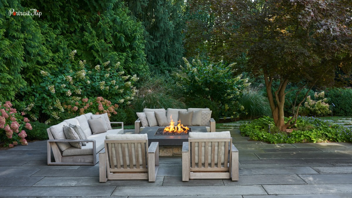 Outdoor living space imagine. White sofas that are in an outdoor space around a bonfire. This is one of the trends in home decor of 2022.