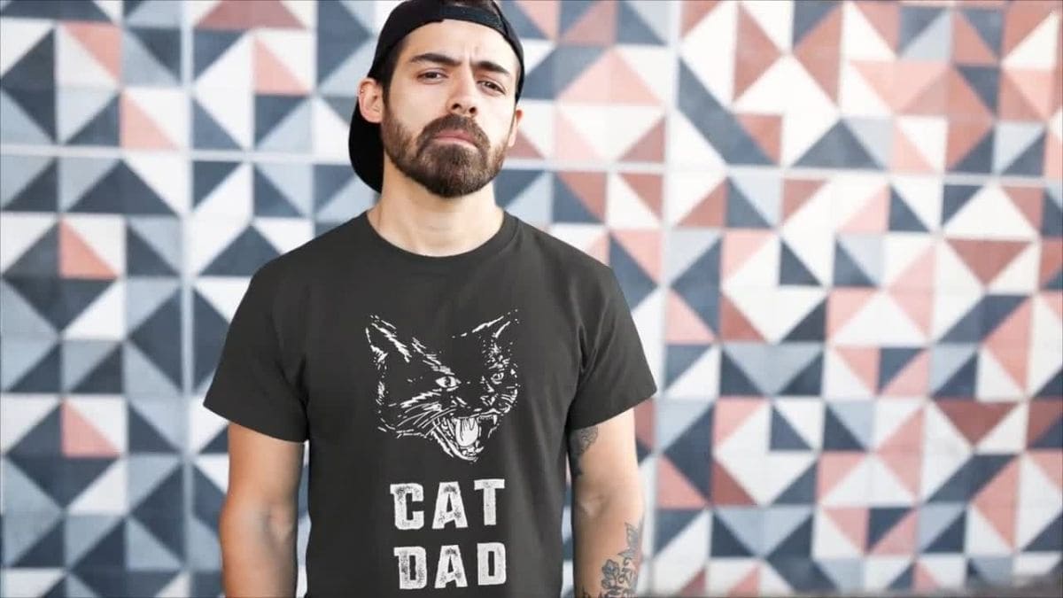 An images showing a man wearing a t-shirt saying cat dad 
