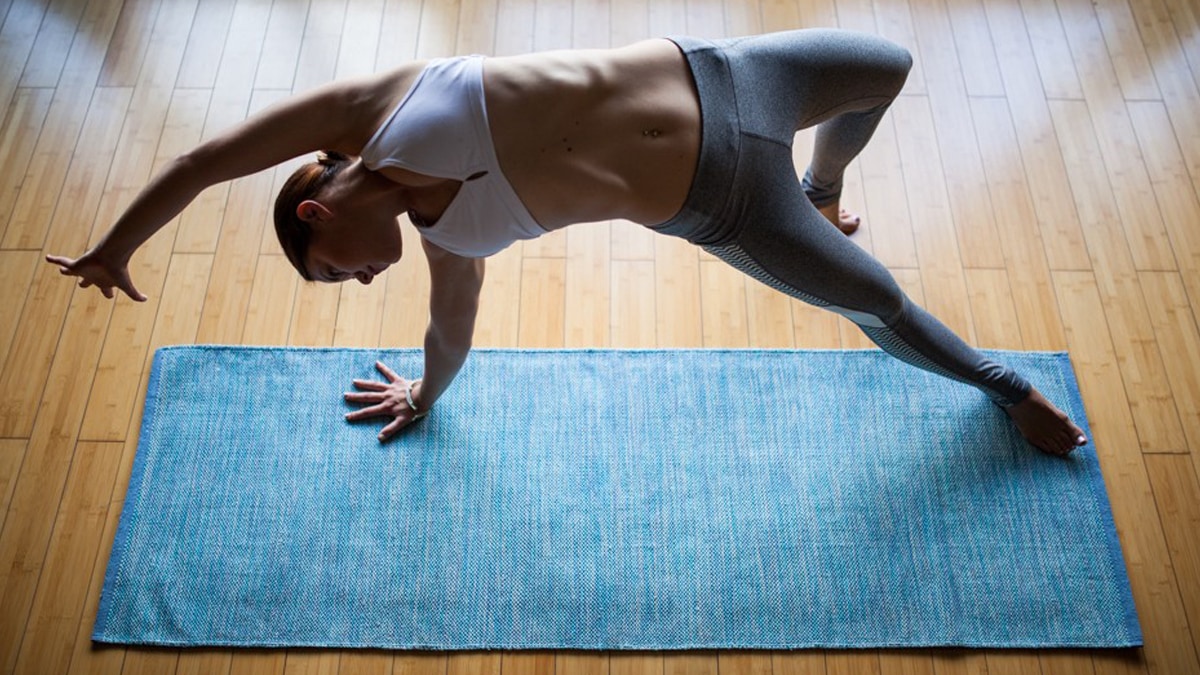 A woman performing yoga exercise on a recyclable cotton yoga mat
