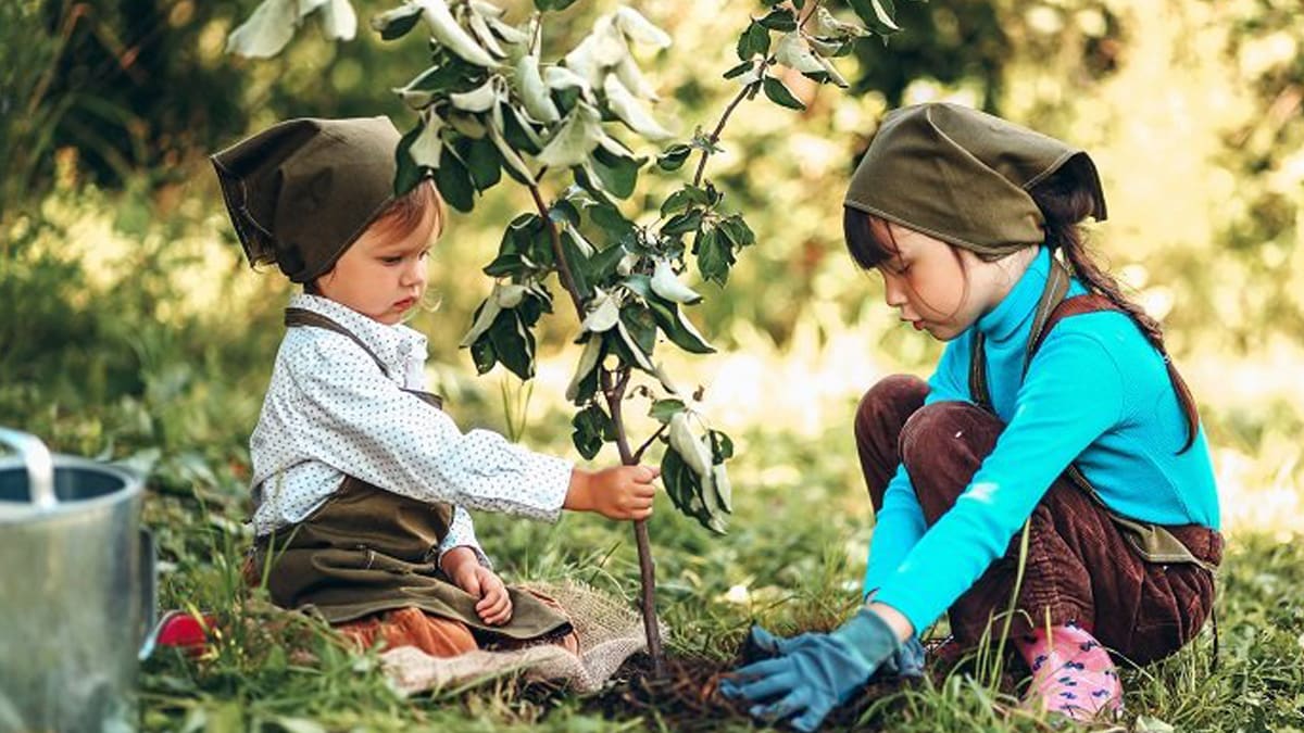 Two kids planting a tree using their eco friendly planting kit
