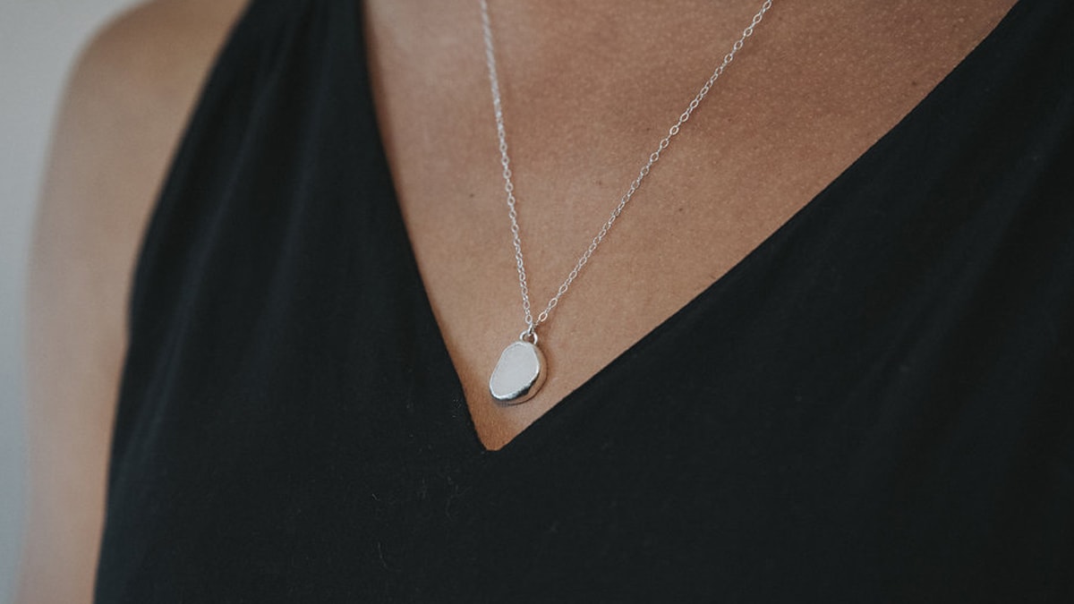 Recycled sea glass necklace worn by a women in a black dress