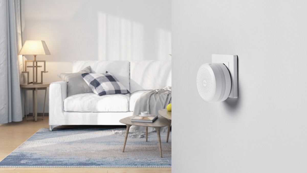 A white smart home censor placed right in the living room