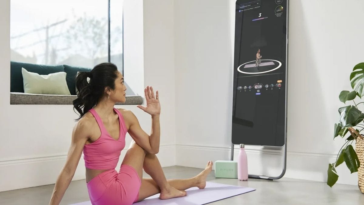 a smart mirror that helps you workout shown in front of a woman who is working out