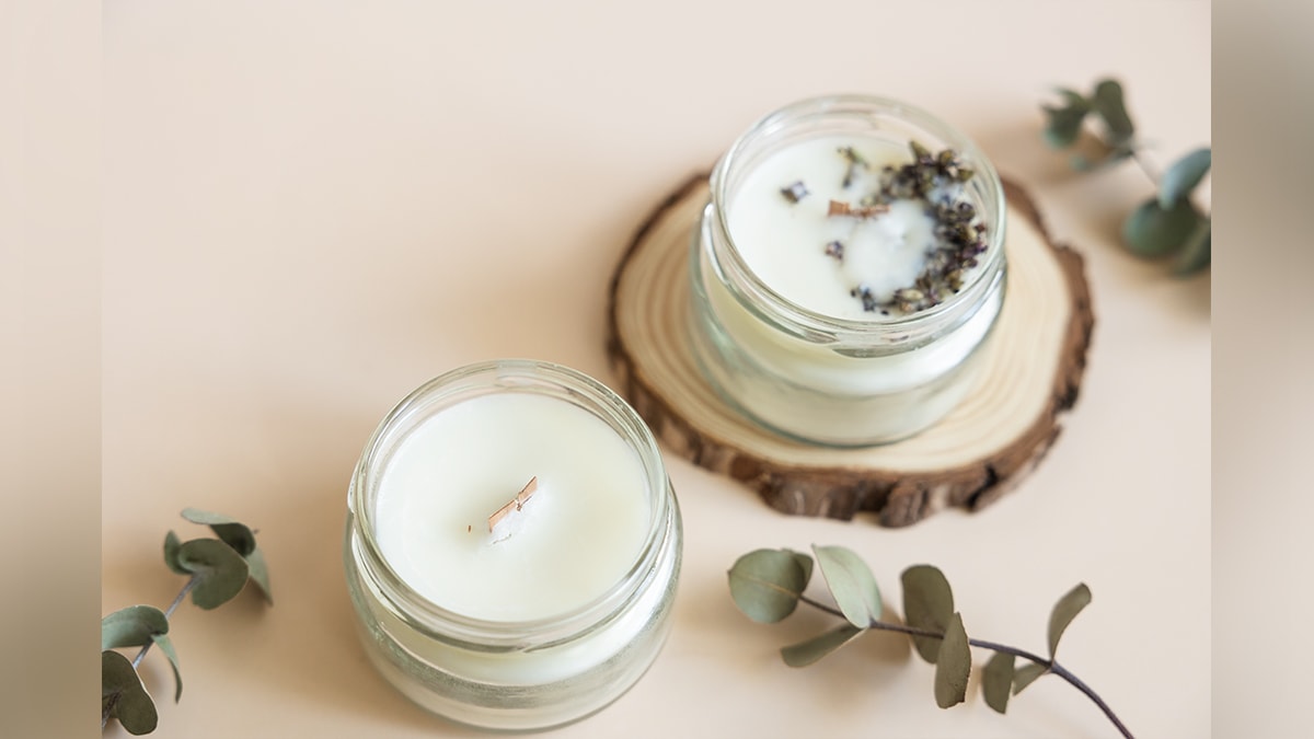 two handmade scented candles on a plain white surface. 
