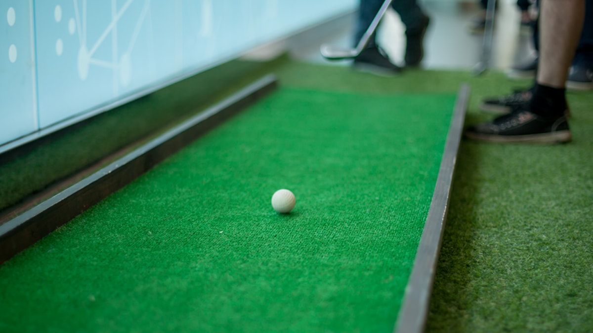 a man playing gold on a mini golf course game