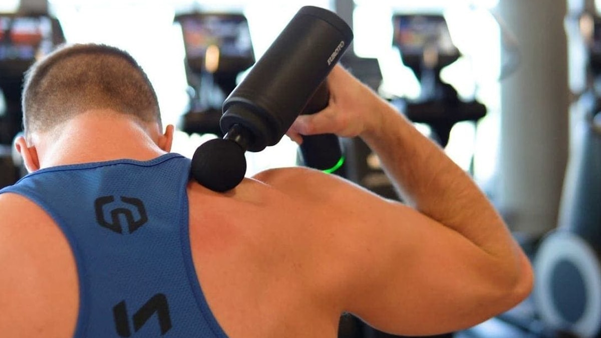 a man is using a body massager at a gym