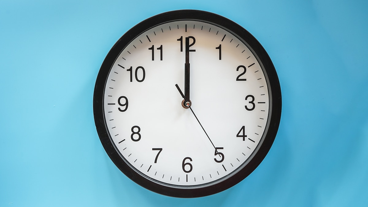 retro wall clock mounted on a blue wall