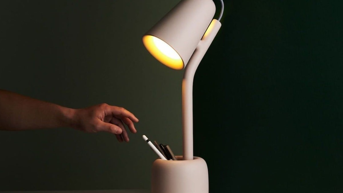a man is about to grab a pen from a table lamp