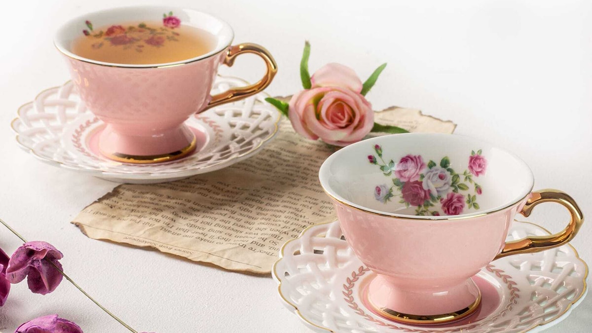 Customized Cup and Saucer Set in pink color with floral detailing on a white table