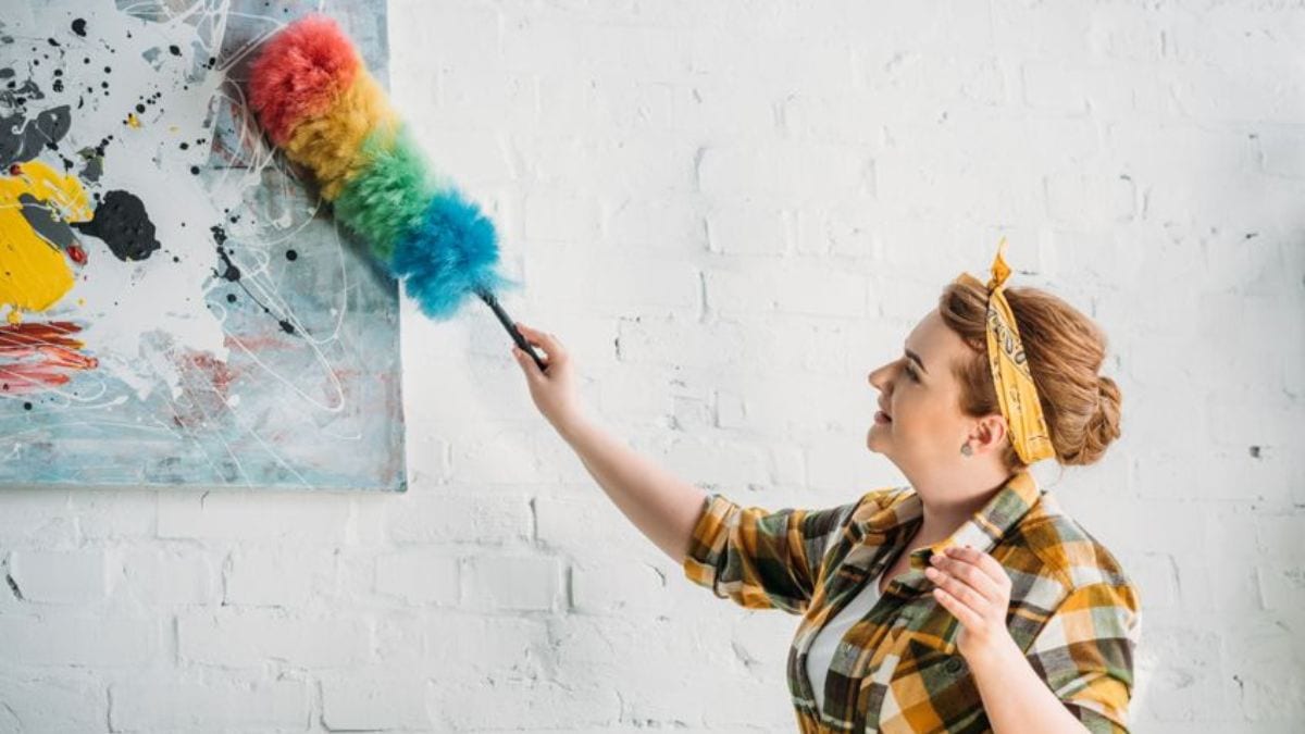 dusting with a feather duster shown as a method to not use while cleaning an oil painting