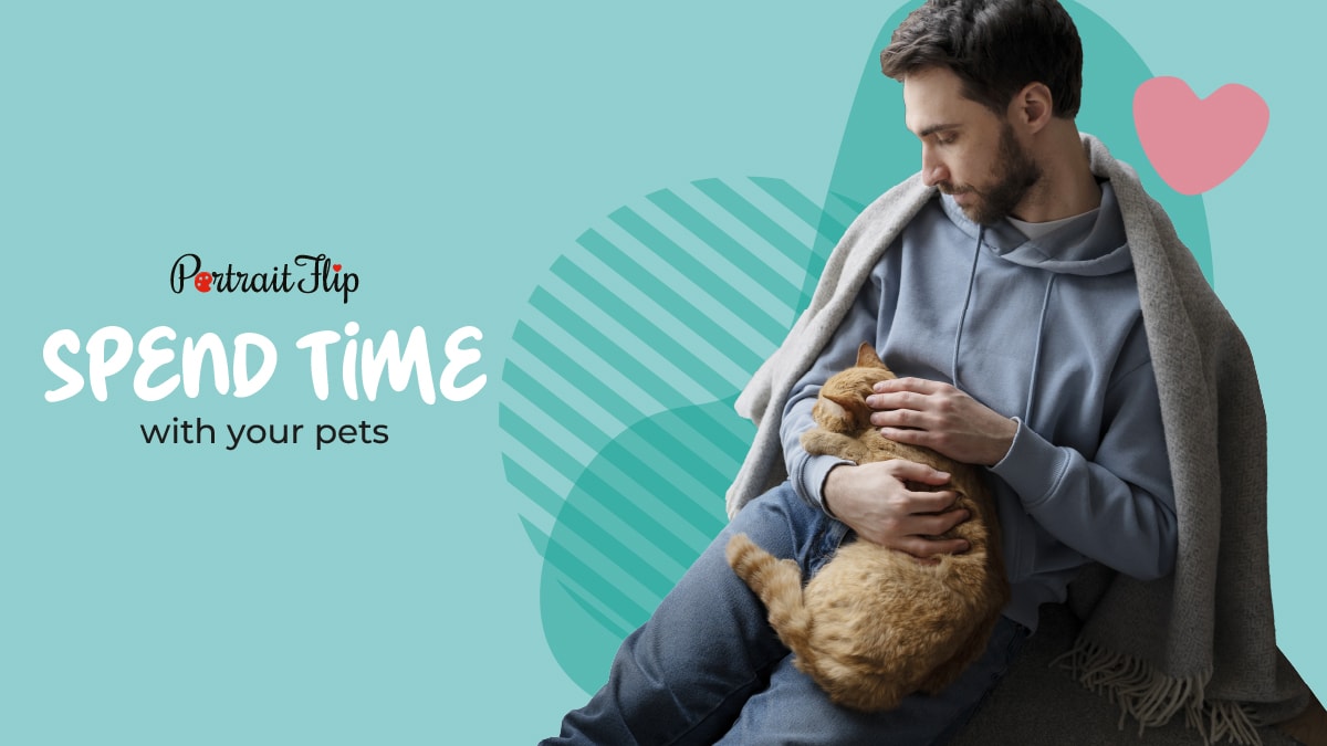 a cute man in a hoodie who is covered by a heated blanket is holding a brown fur cat and is looking at her with all his innocence