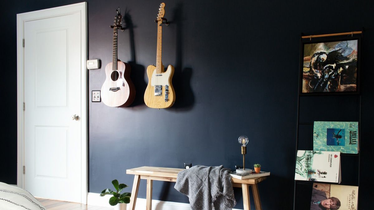 Two guitars displayed on a blue wall creating an instrument corner