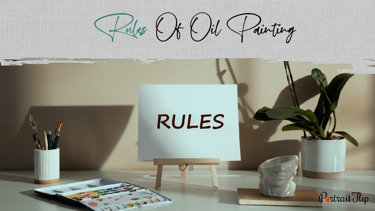 A plain white canvas that has rules written on it, a pallet, a pen stand and a flower pot placed on a white table. The text reads rules of oil painting.