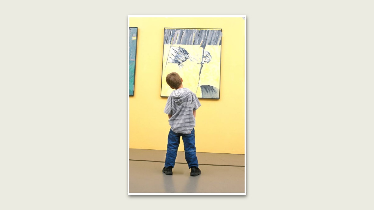 A kid looking at an abstract painting