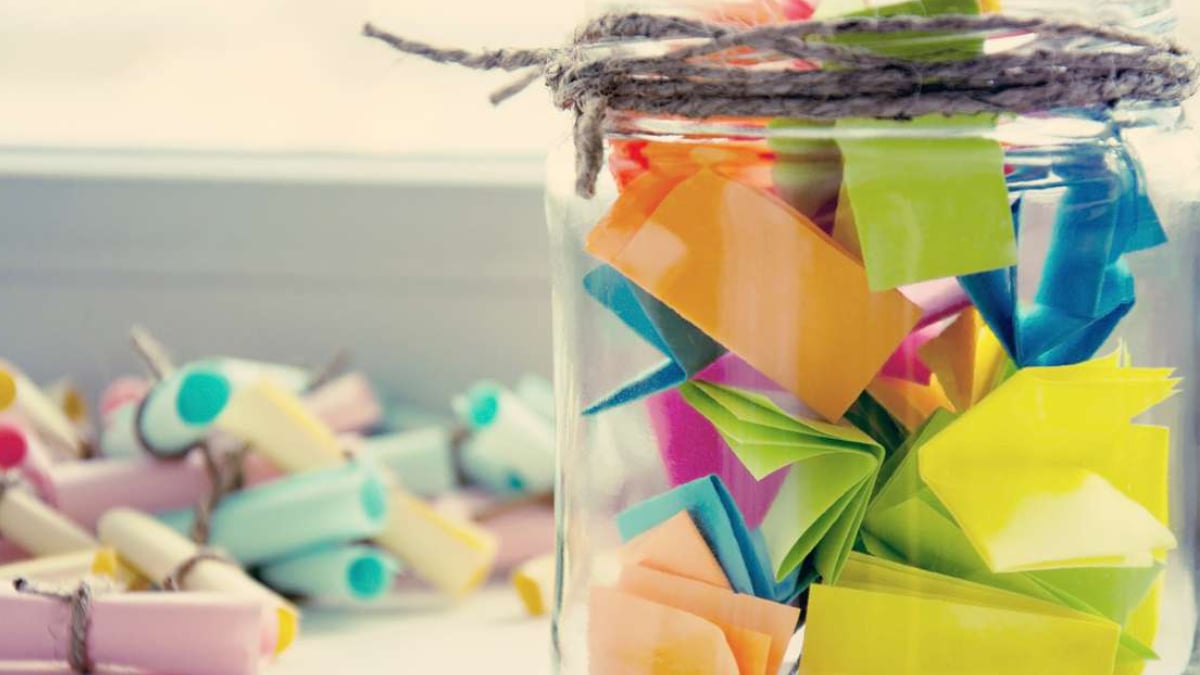 A memory jar on display that is filled with colorful chits