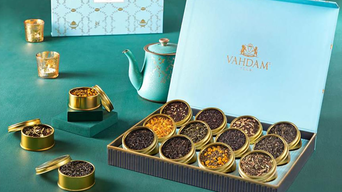 A assorted tea gift set of Vahdam with a tea pot and three flavors placed in separate tin box