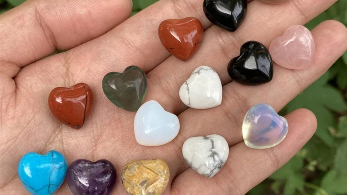 Closeup shot of different color crystal heart in a hand