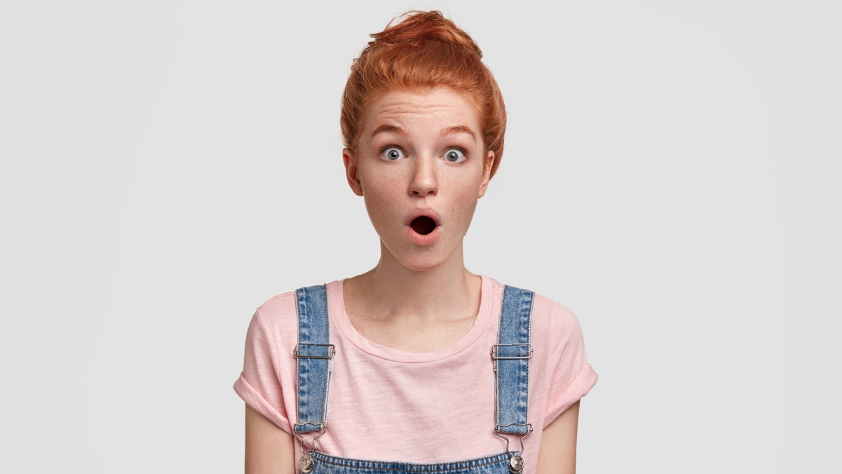 A girl with red hair is suprised