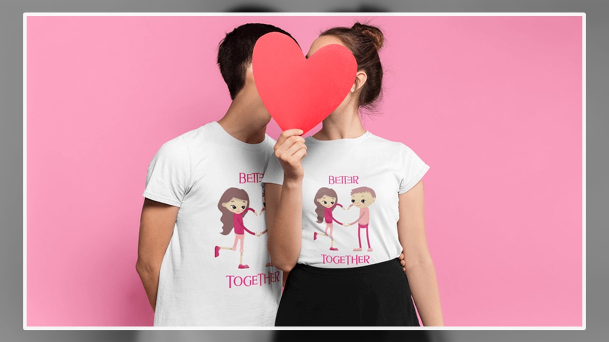 A couple hiding behind the heart shape paper wearing t-shirts which shows better together text