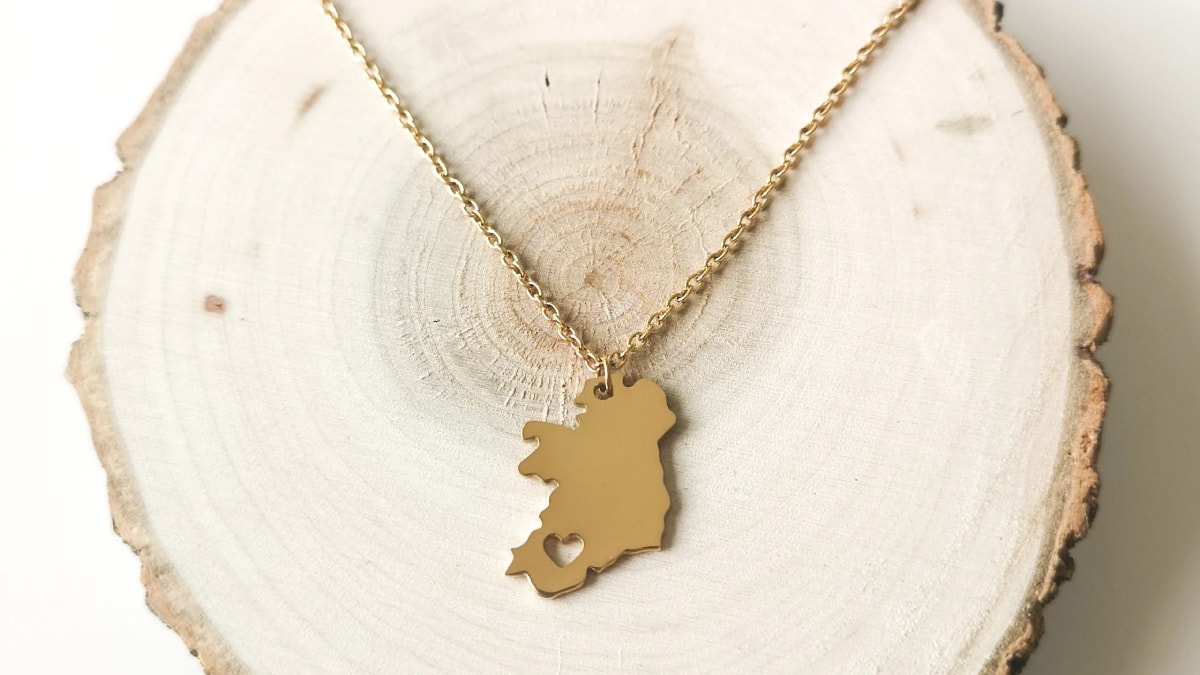 Ireland necklace placed on a cut wood