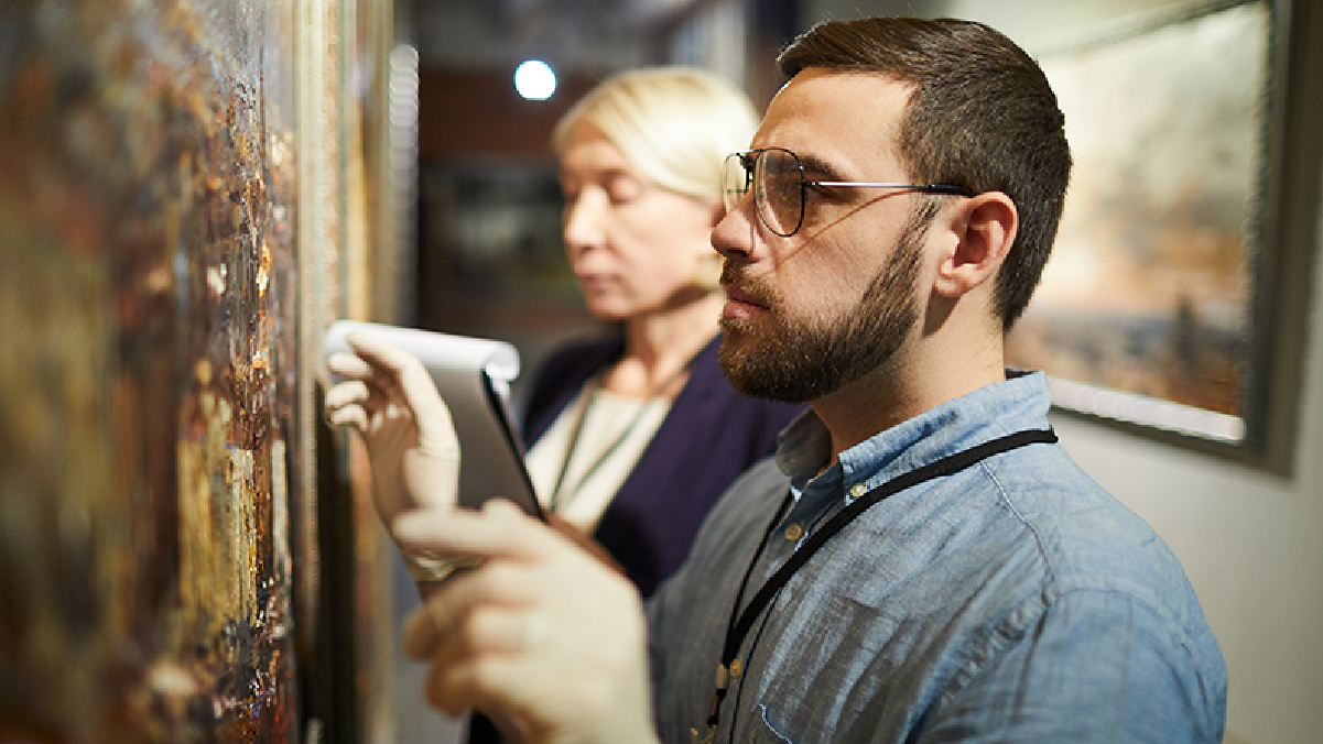 an examiner looking at a painting 