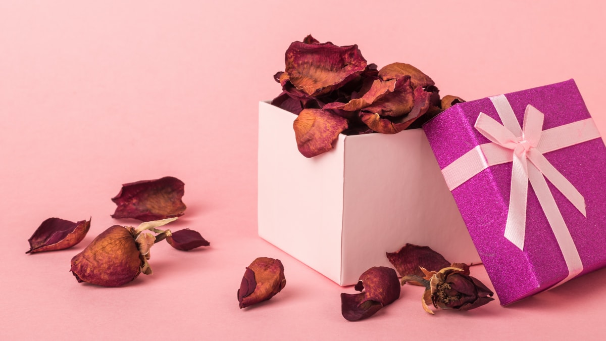 Dried rose petals spread over the pink background and in the white box known as Potpourri