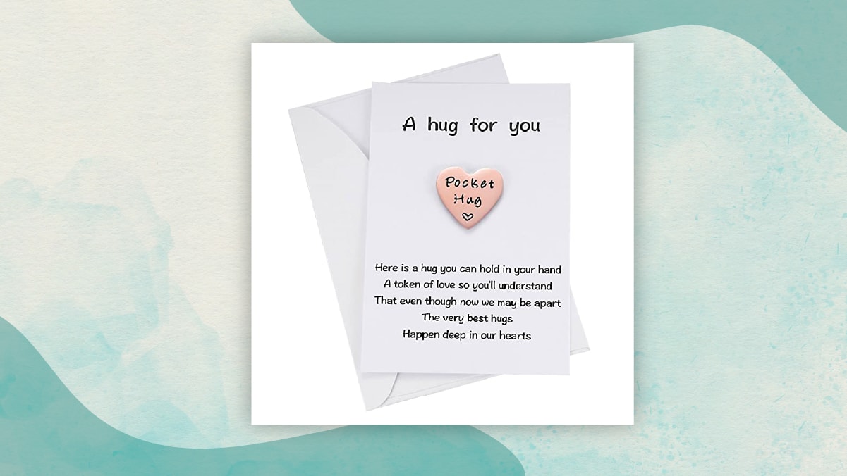 A white letter note with " A hug for you" written on it along with a pink heart with Pocket Hug written on it as gifts for long distance relationship. 