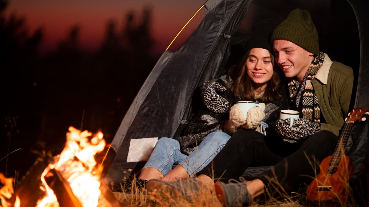 A couple holding each other while camping outside 