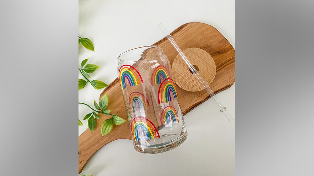 A drinkware with rainbow print placed on a wooden plate.