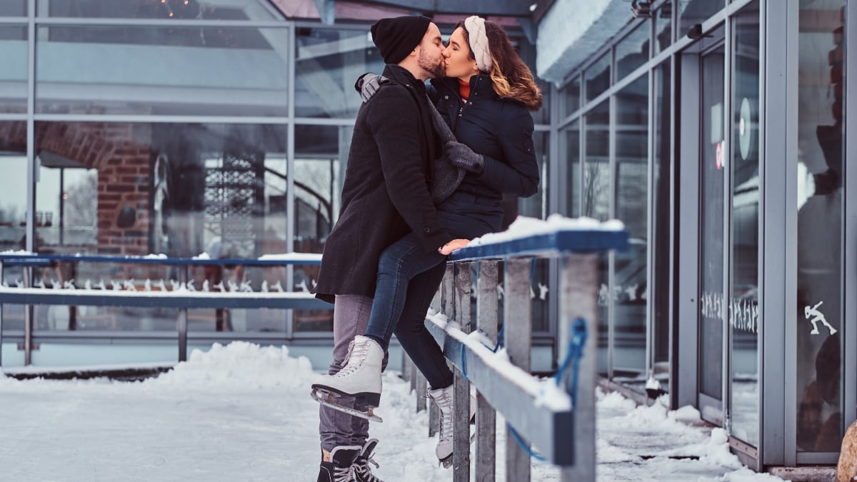 Couple kissing each other while ice skating