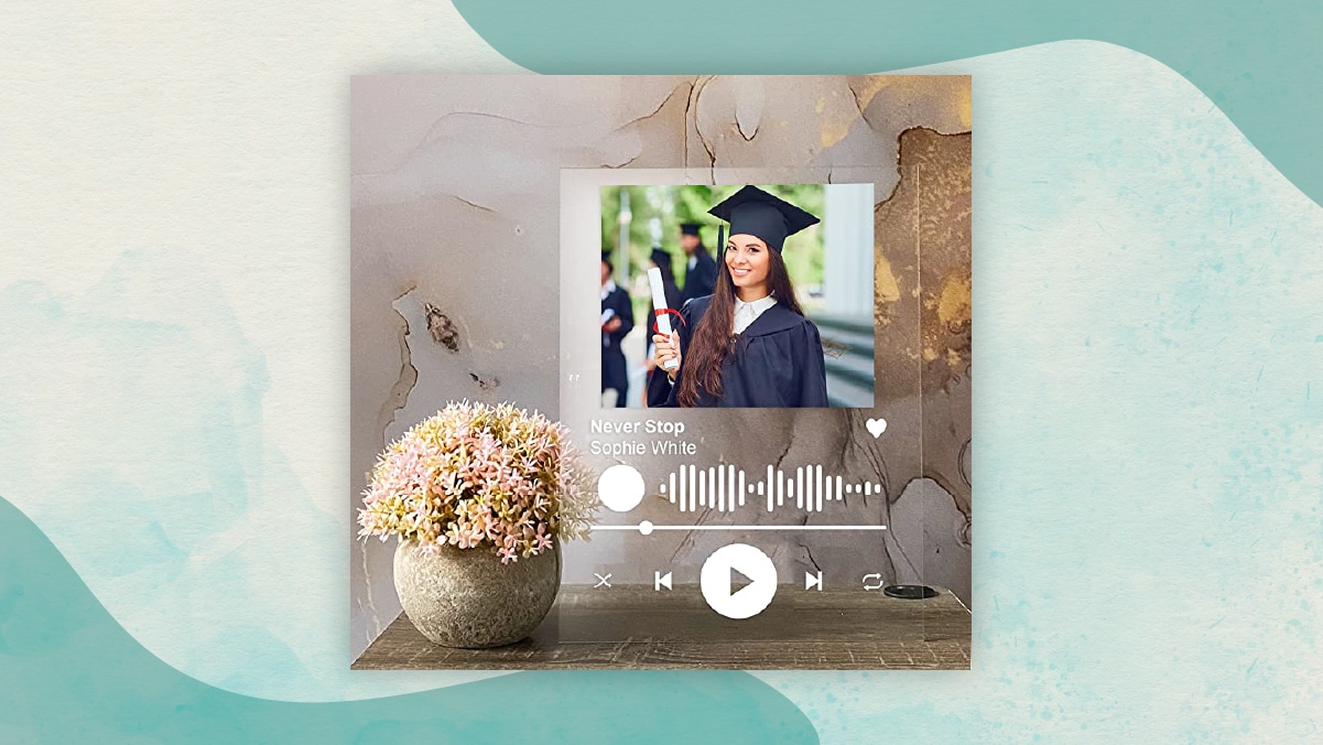 A personalized acrylic album cover with a photograph of a girl holding a degree in her hand and wearing a black gown and a cap. 