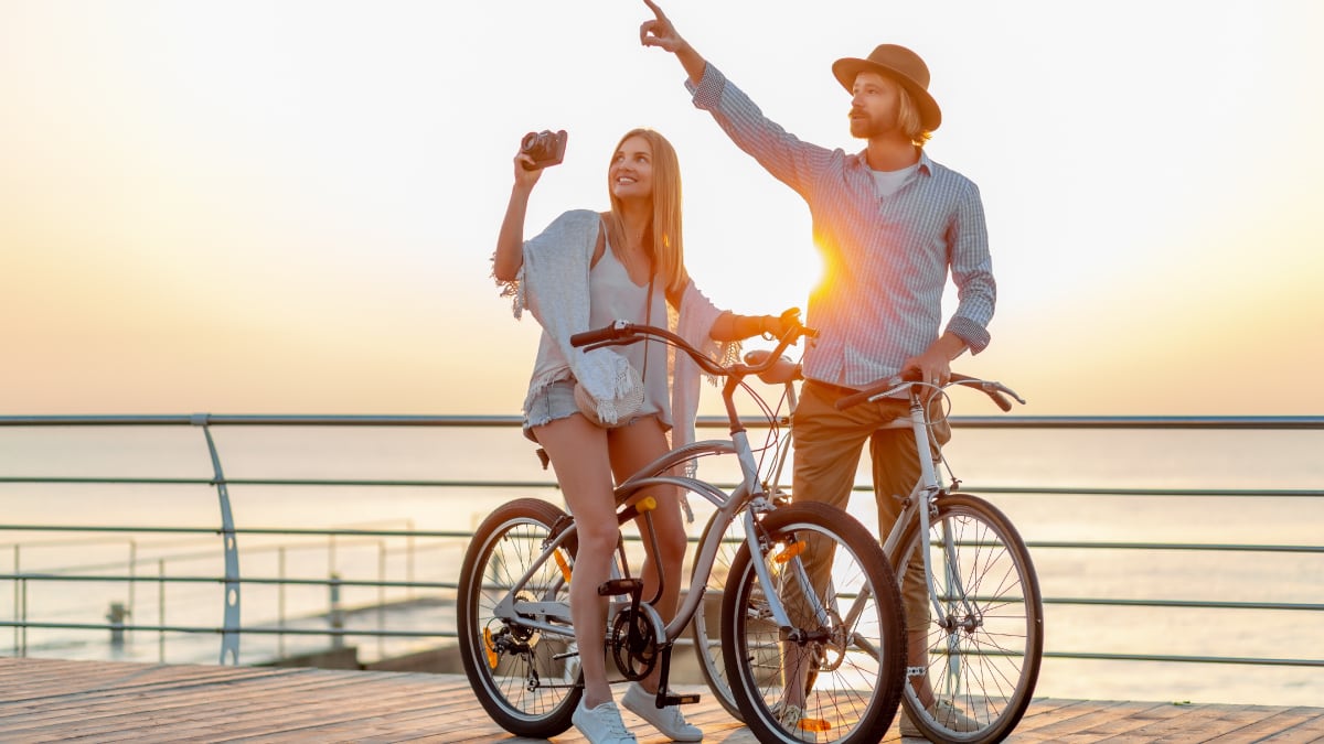 Couple riding bikes while clicking the picture of the view
