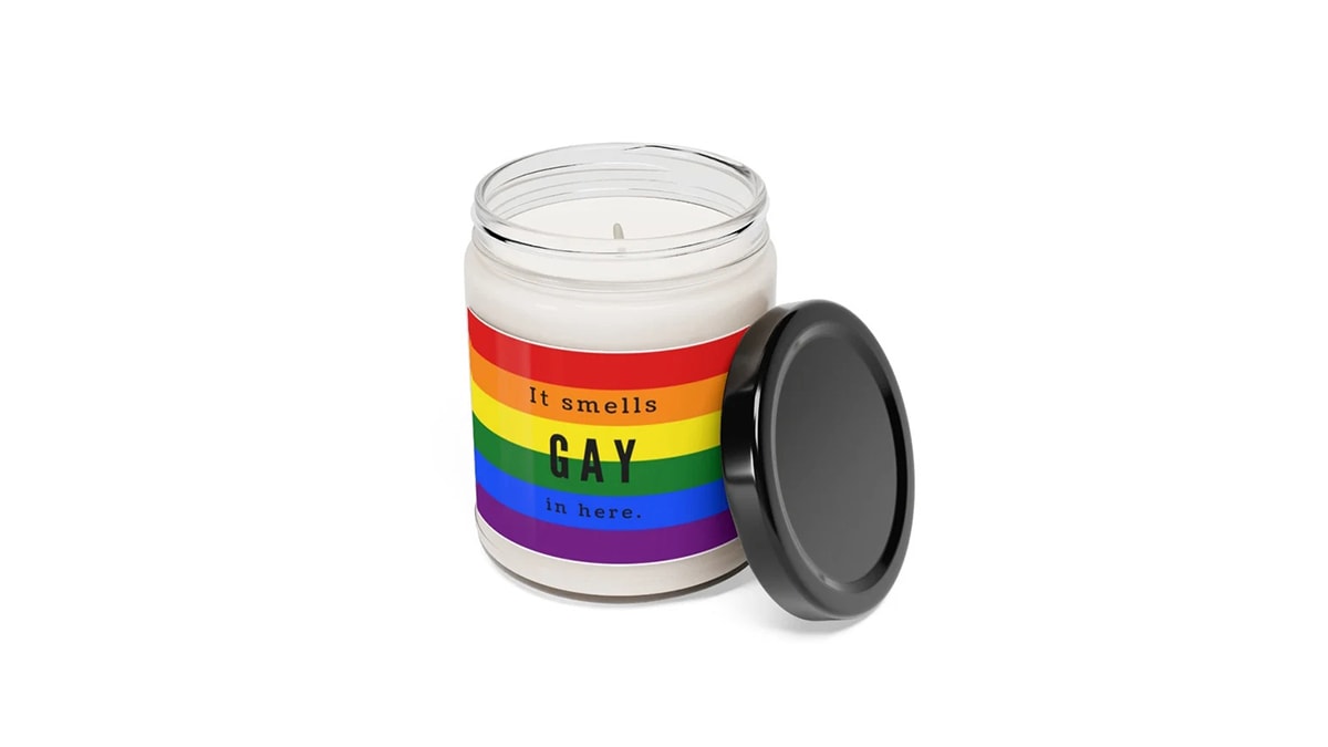 A jar of scented candle with a label 'it smells gay in here' on a rainbow background. 